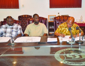 Chief Minister Hughes (far right) signing FFSD with Ministers Evan Gumbs and Jerome Roberts looking on