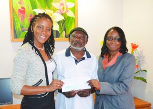 Marissa Hughes (left) and Kedean Ruan presenting cheque to Renford Kelsick