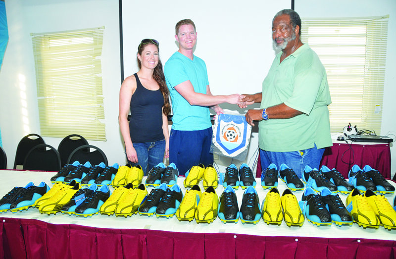 AMERICAN FOOTBALLER PRESENTS CLEATS FOR ANGULLIAN PLAYERS