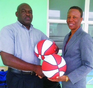 Ornette Gumbs principal of AARPS handing over basketballs to Acting Director of Sports