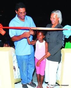 Dr. Bryan Cutting Ribbon assisted by Little Tiandra Carter and Attorney Pam Webster