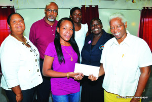 Ms. Gumbs (centre) being presented with cheque by Mrs. Verna Fahie