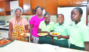 Ms Merlin Fleming (cook) and Principal Mavis Fleming-Drakes with students at lunch