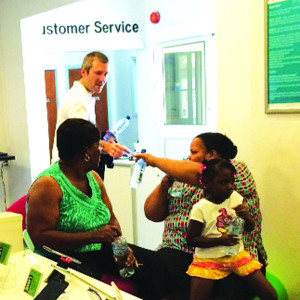 Martin Roos, CEO LIME Caribbean hands out bottles of water to LIME customers at LIME Anguilla office while they charged their mobiles, called family and friends  as well as to top up and access other LIME services in the aftermath of Hurricane Gonzalo which ravaged the island on October 13.