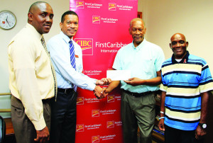 Manager Assistant Corporate CIBC FirstCaribbean Anguilla Ivor Lazare handing over cheque to Treasurer Anguilla Cancer Society Clifton James.