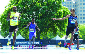 Zharnel Hughes (far right) finishing race with Usain Bolt and other competitors (Photo contributed)