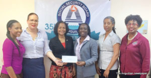 Mrs Rosanna Browne handing over contribution to Malliouhana Poetry Committee Members Dr